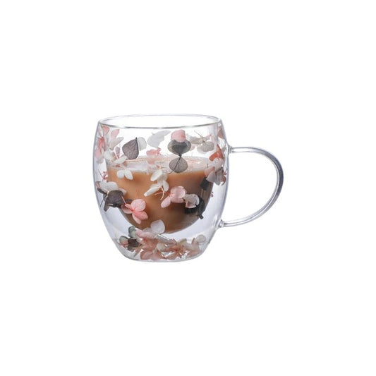 Tasse en céramique grise avec anse à double paroi et décorée de pétales de fleurs roses et blancs, d'une capacité de 250 ml.